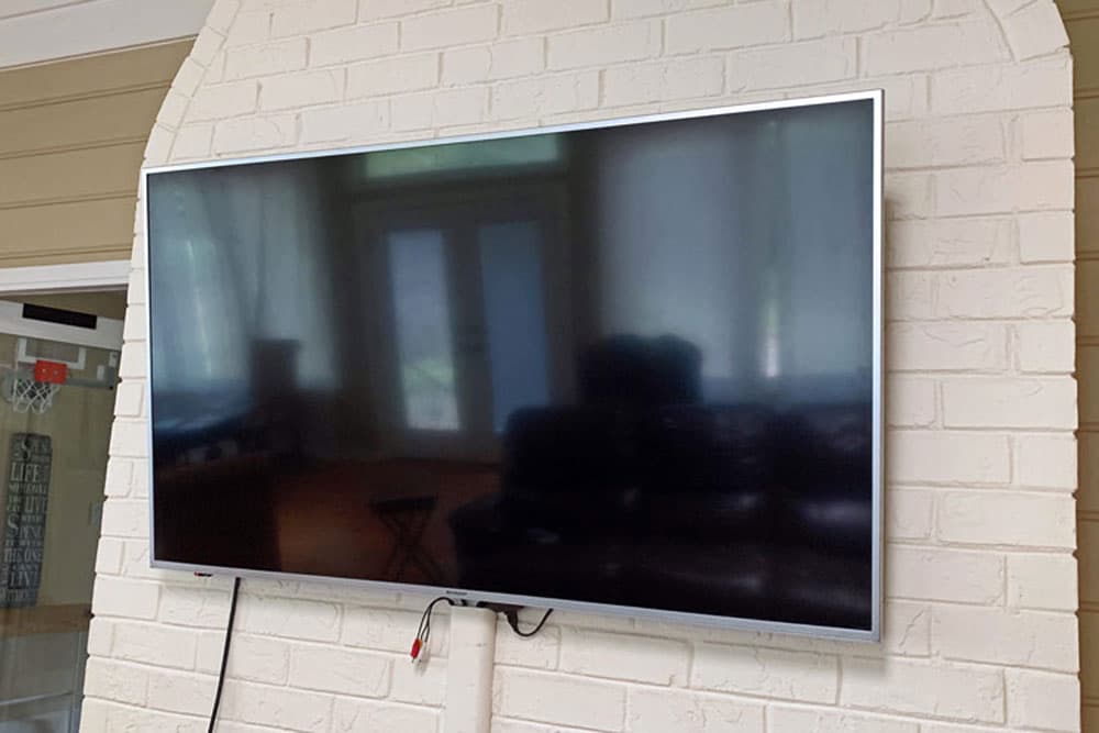 large television mounted to white brick fireplace in living room of desoto county mississippi residential home theater installer.