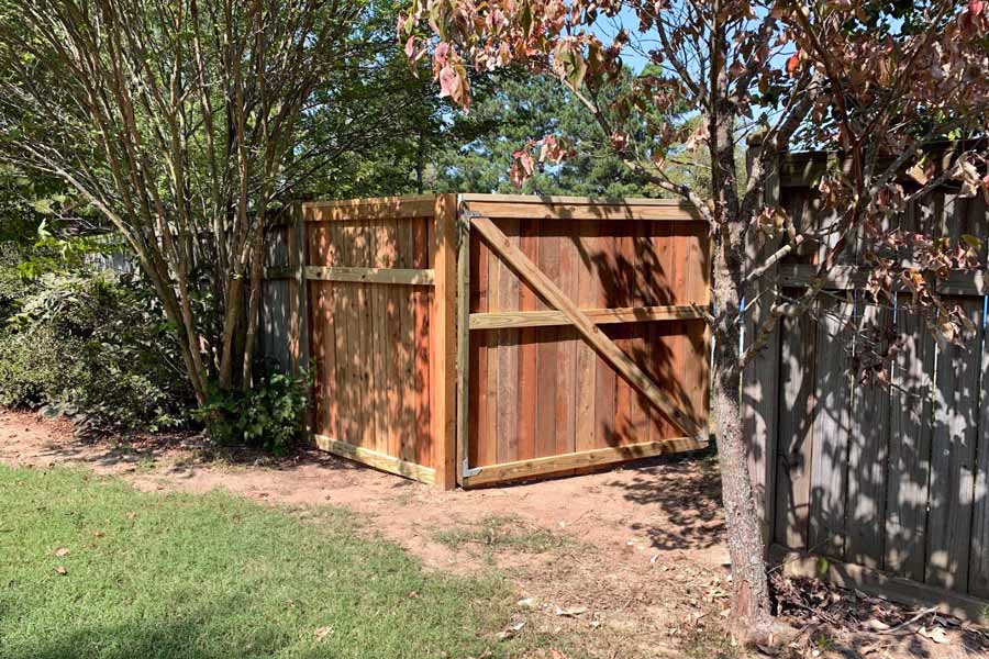 beautiful custom designed 6 foot wooden gate attached to old fencing by local builder in olive branch mississippi