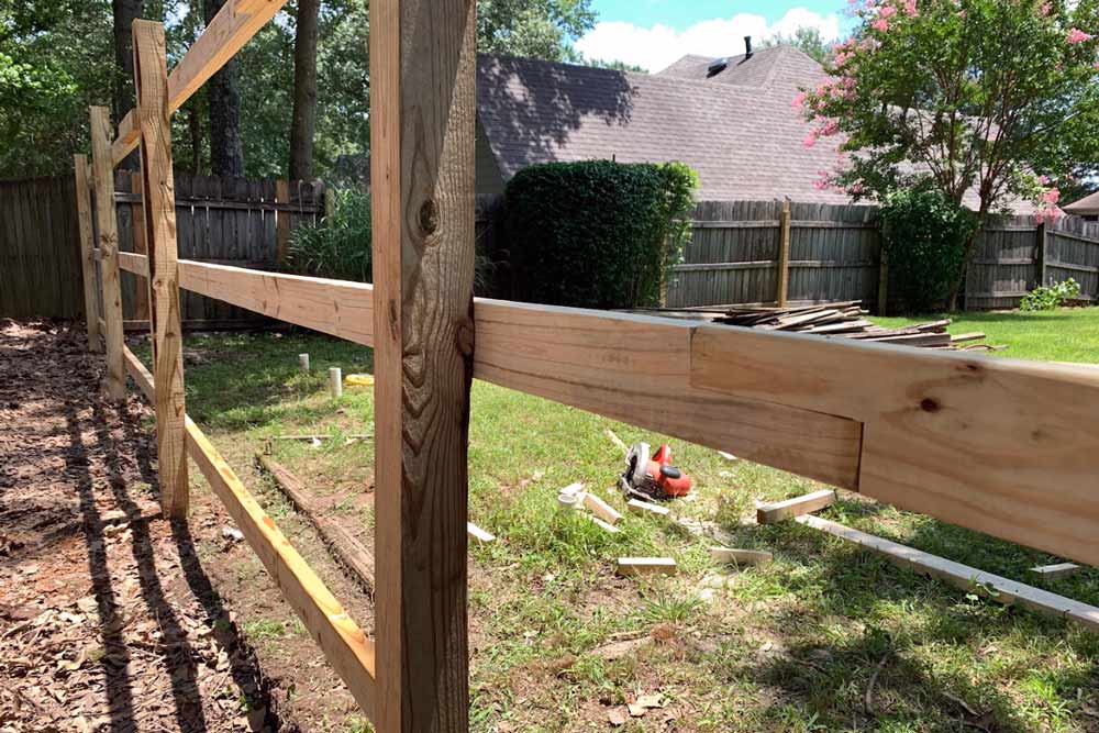 custom designed wooden fencing rows over posts extra brace by handyman services near memphis tennessee backyard construction