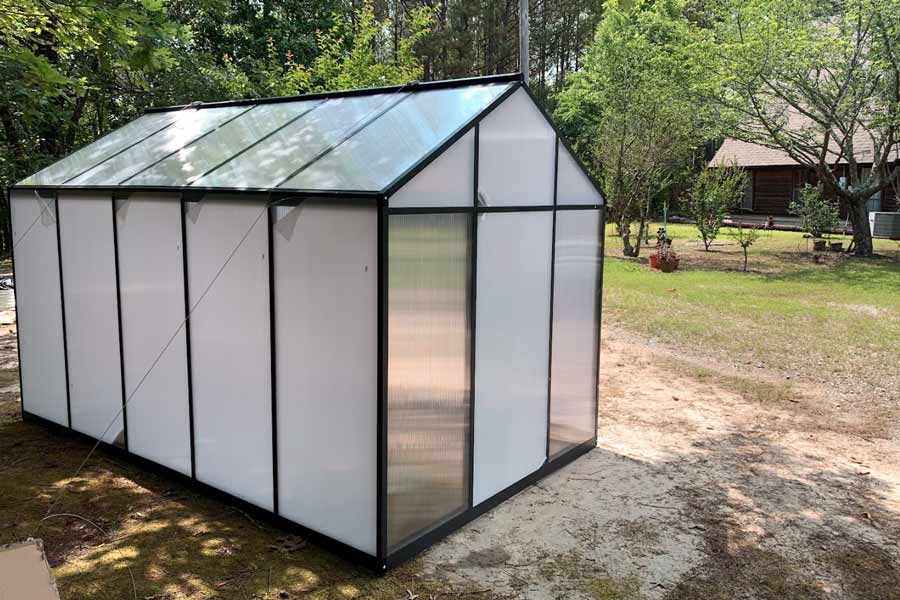 green house assembly project with plastic still on windows outside farmhouse in holly springs mississippi