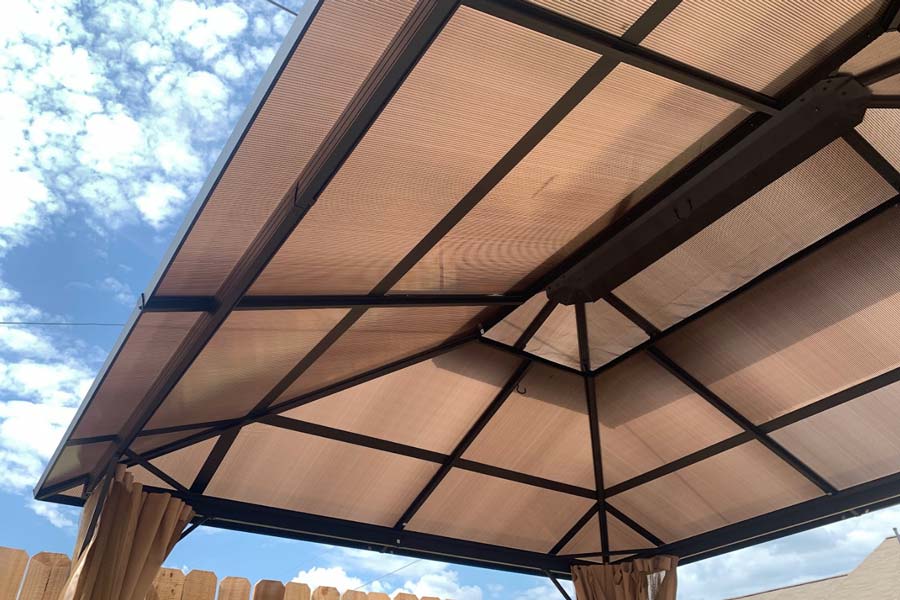 looking up at the blue sky and clouds underneath store bought metal gazebo installed by outdoor structure builder in olive branch ms