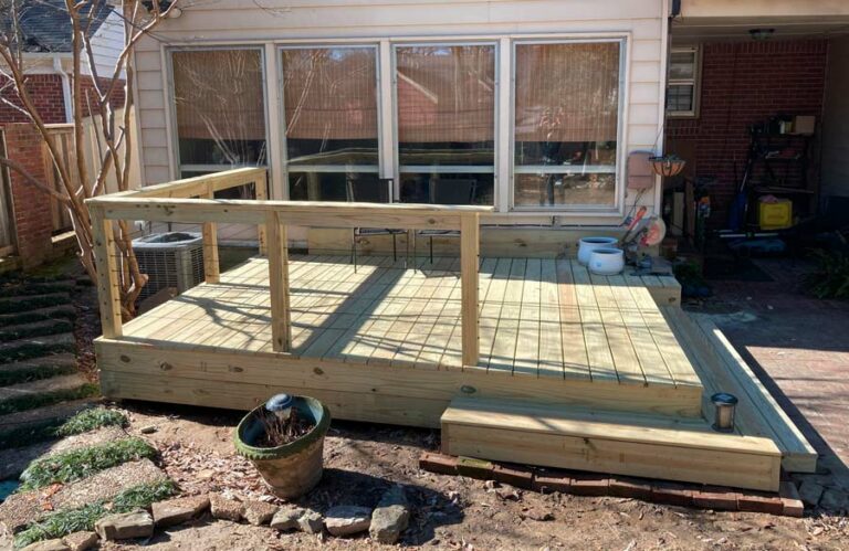 solid wood 15" high backyard decking in memphis tennessee near university where railing was custom made with crimped cables for barrier and wrap around steps.