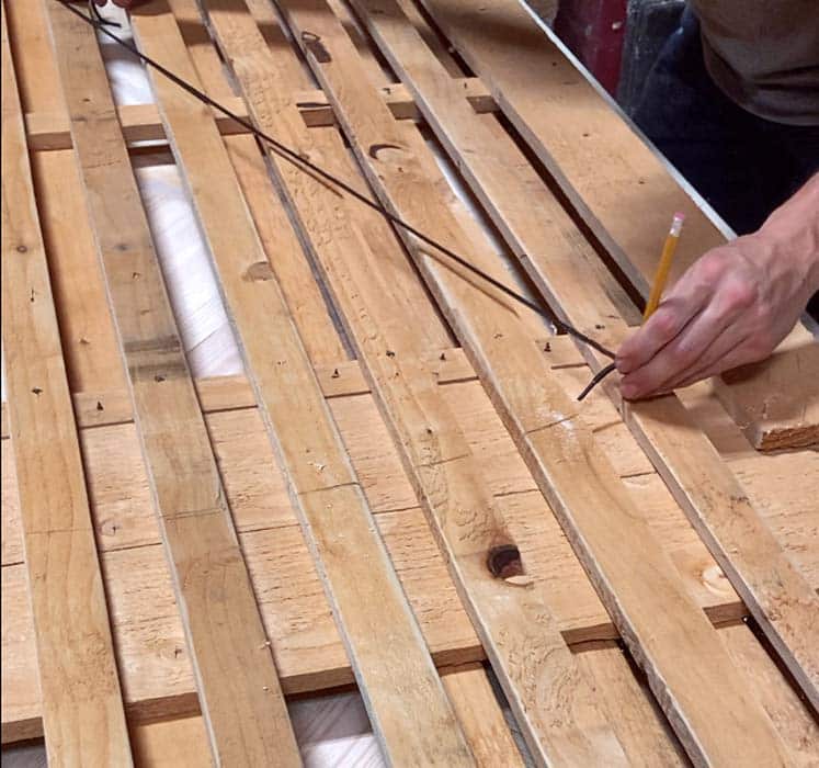 old school carpenter using shoe string and pencil to draw perfect arched top of gate using ripped cedar boards for brick wall privacy near Midtown Memphis Tennessee