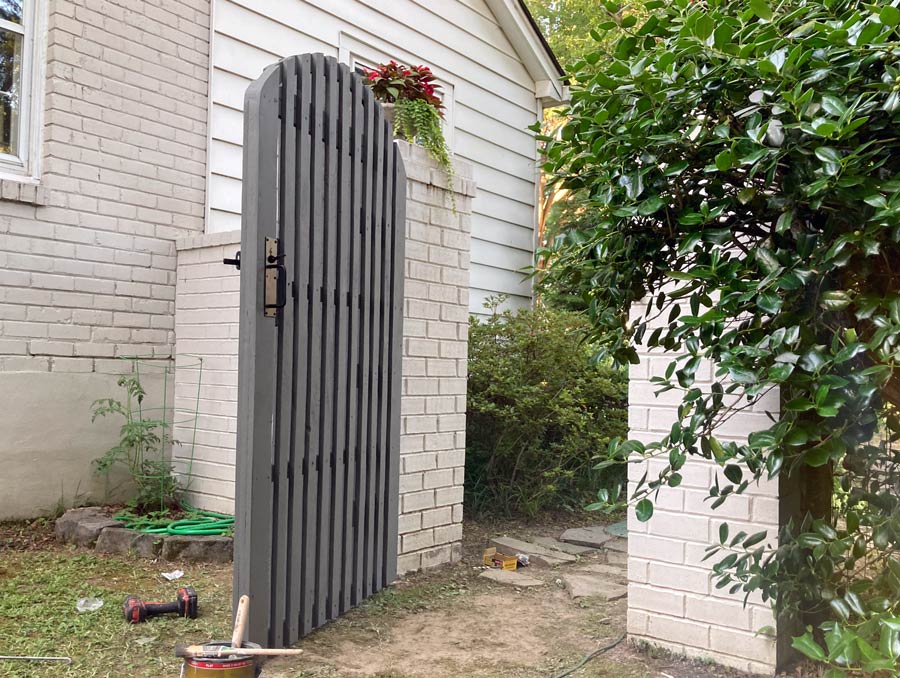 good angle of this unique crafted wooden gate on brick fence in old town Memphis TN showing slim picket privacy and sleek look with latch lock set by 1 Handy Craftsman