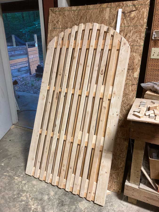 getting started on cedar picket fence sanding down smooth for client in midtown leaning up against some plywood at my workshop in Olive Branch, Mississippi