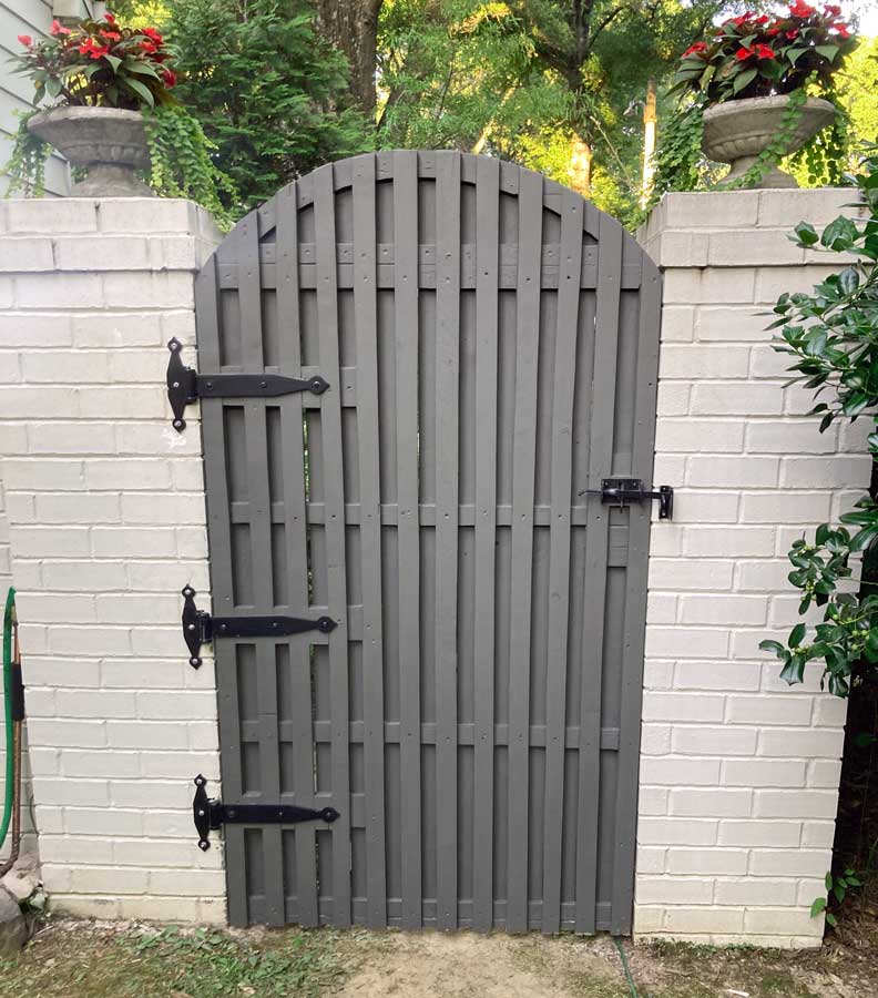 creating personal backyard space and privacy for local memphis professor beautiful flat gray painted gate with black iron hardware hung on white brick fencing by 1 Handy Craftsman in Olive Branch MS