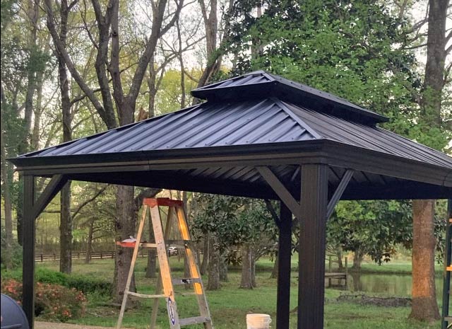 completed roofing for metal gazebo with vent ladder in background finishing installation in collierville tennessee