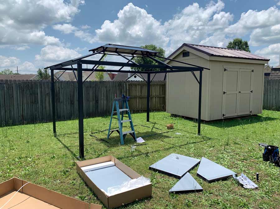 metal frame for backyard gazebo assembled and preparing plastic roof pieces for installation in southaven mississippi
