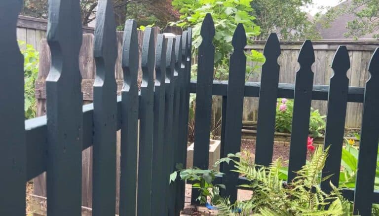 View of newly installed garden picket fence painted dark green corner by 1 Handy Craftsman in Olive Branch Mississippi.